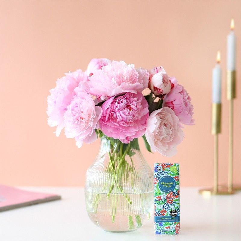 Roze pioenrozen in een glazen vaas