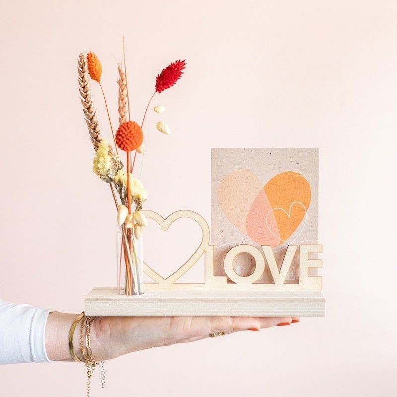 Brievenbuspakketje met houten plankje, houten plank met hart en love tekst en een vaasje met naturel en oranje droogbloemen