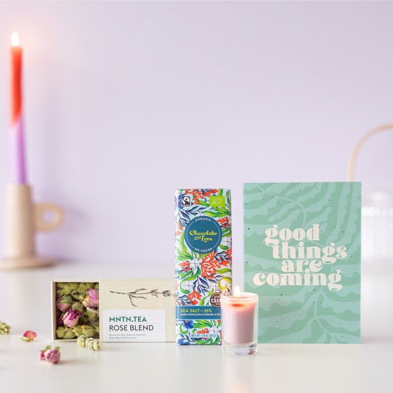 Brievenbuspakketje met een doosje rozen thee, chocolade puur zeezout en een mini roze kaars