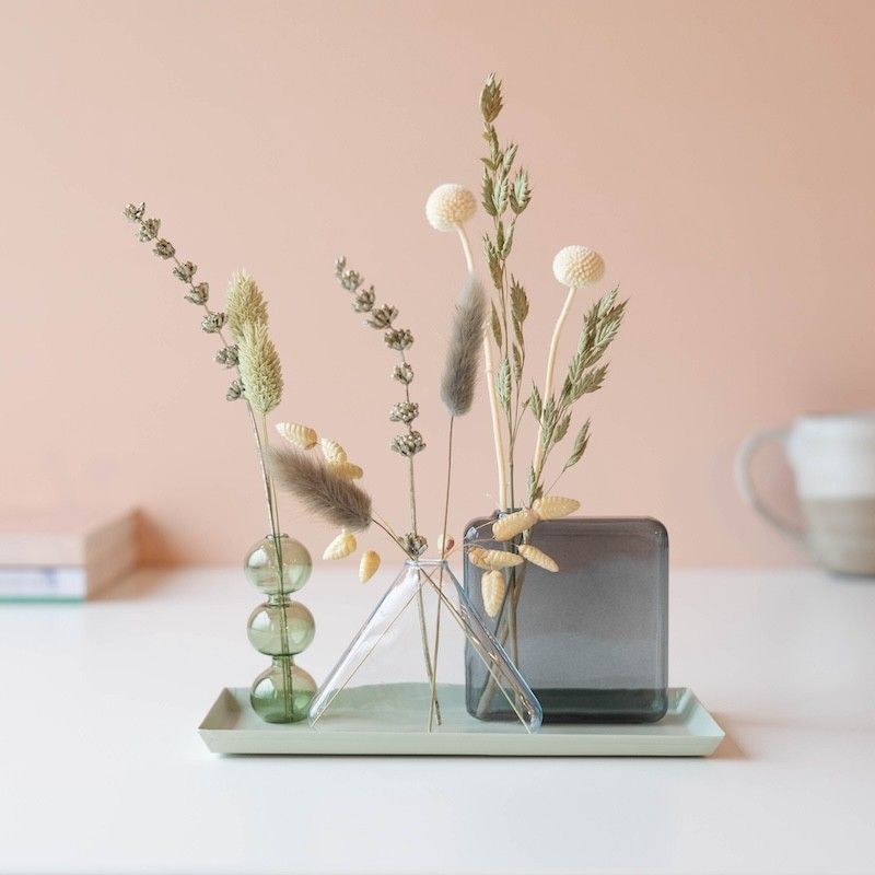 Drie verschillende vaasjes met droogbloemen op een plateau 