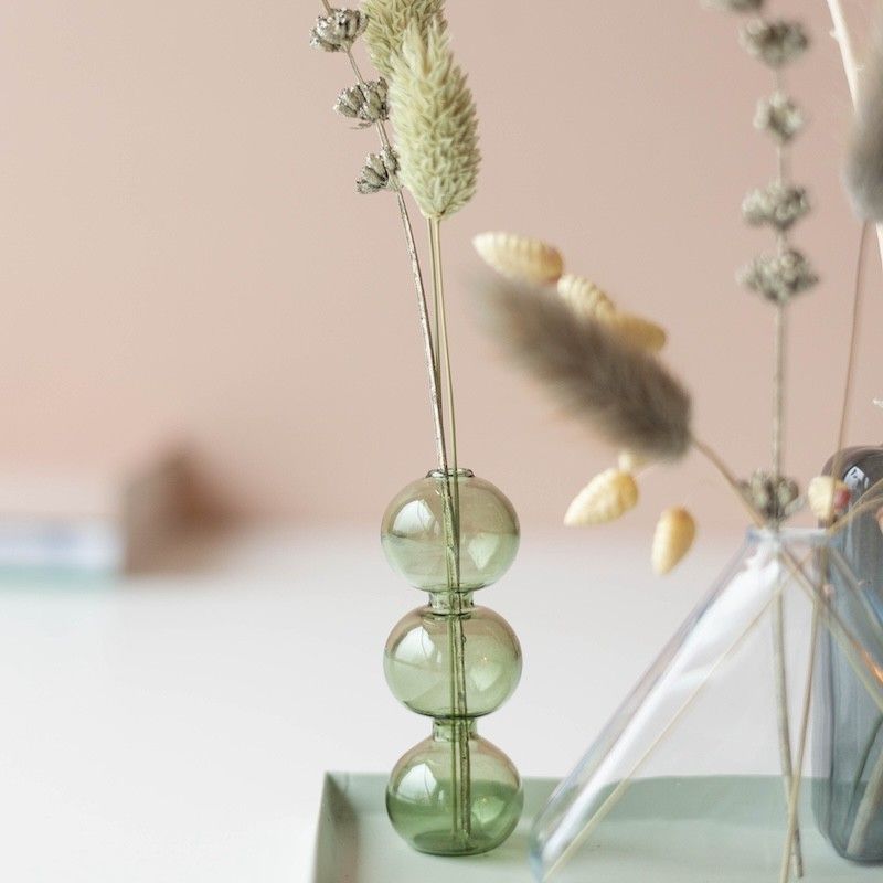 Drie verschillende vaasjes met droogbloemen op een plateau 