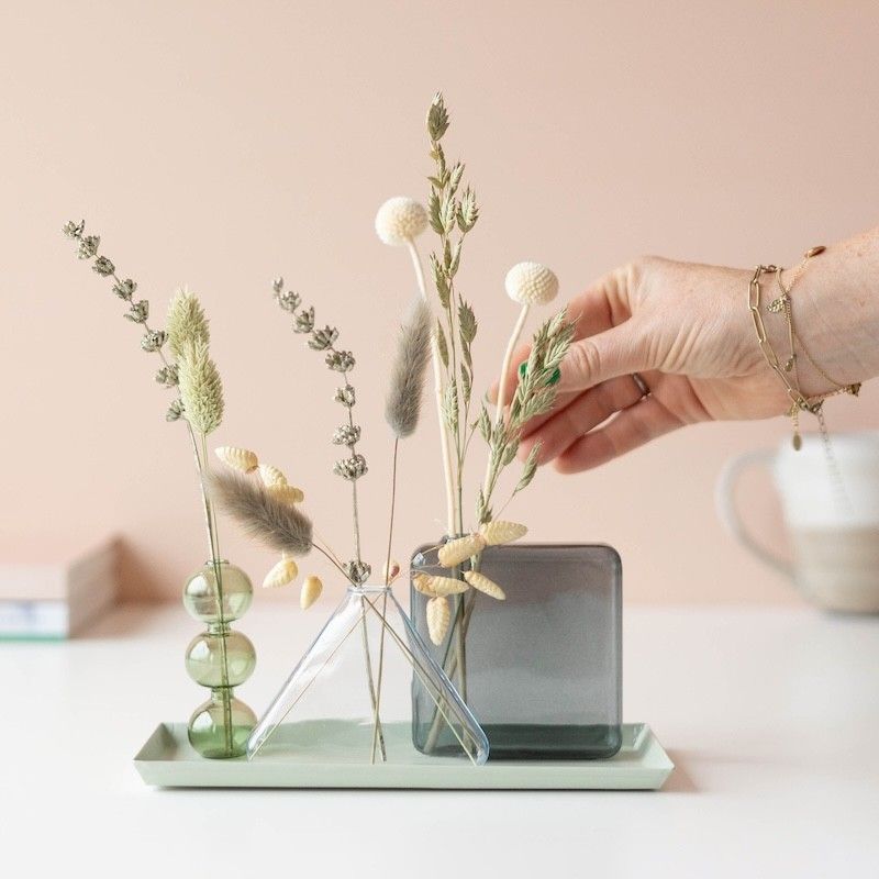 Drie verschillende vaasjes met droogbloemen op een plateau 