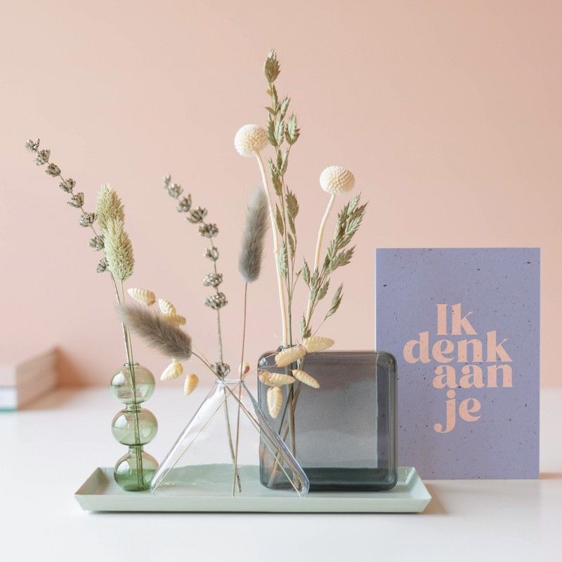 Drie verschillende vaasjes met droogbloemen op een plateau 