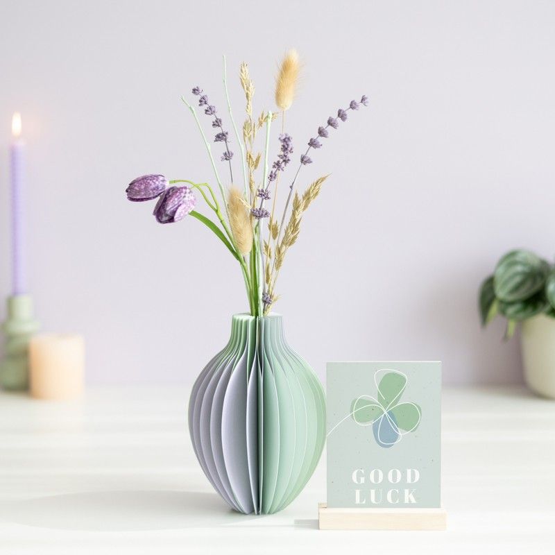 pastel groen en paarse vouwvaas met paarse en naturel droogbloemen en een houten plankje ernaast waar een kaart in gezet kan worden