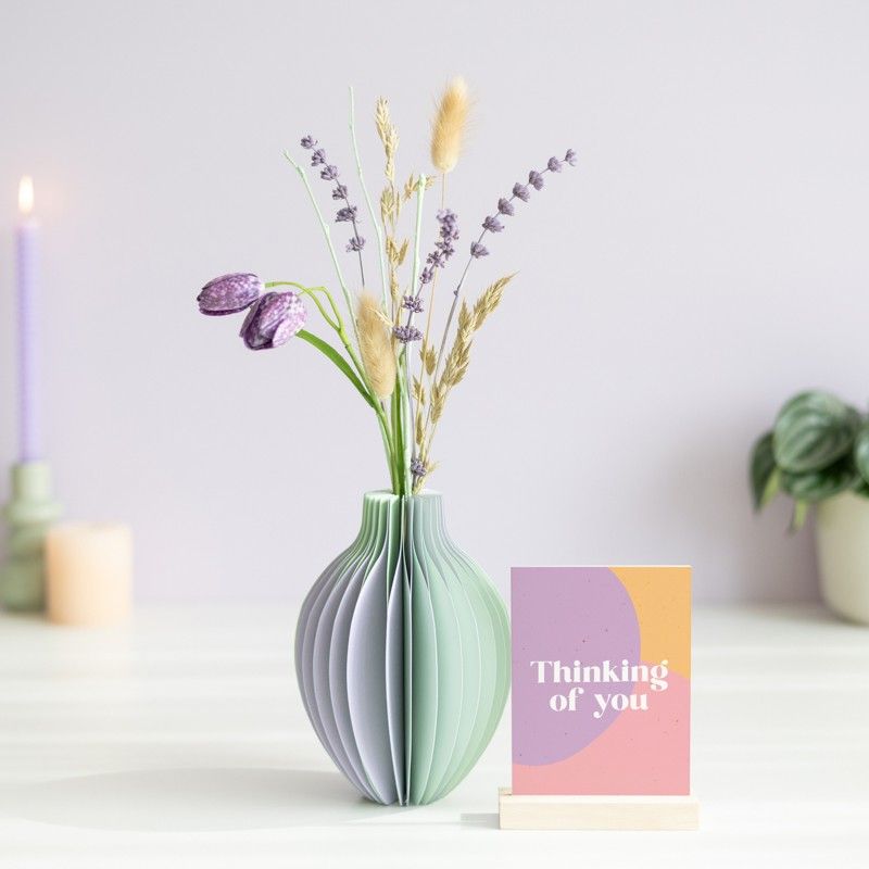 pastel groen en paarse vouwvaas met paarse en naturel droogbloemen en een houten plankje ernaast waar een kaart in gezet kan worden