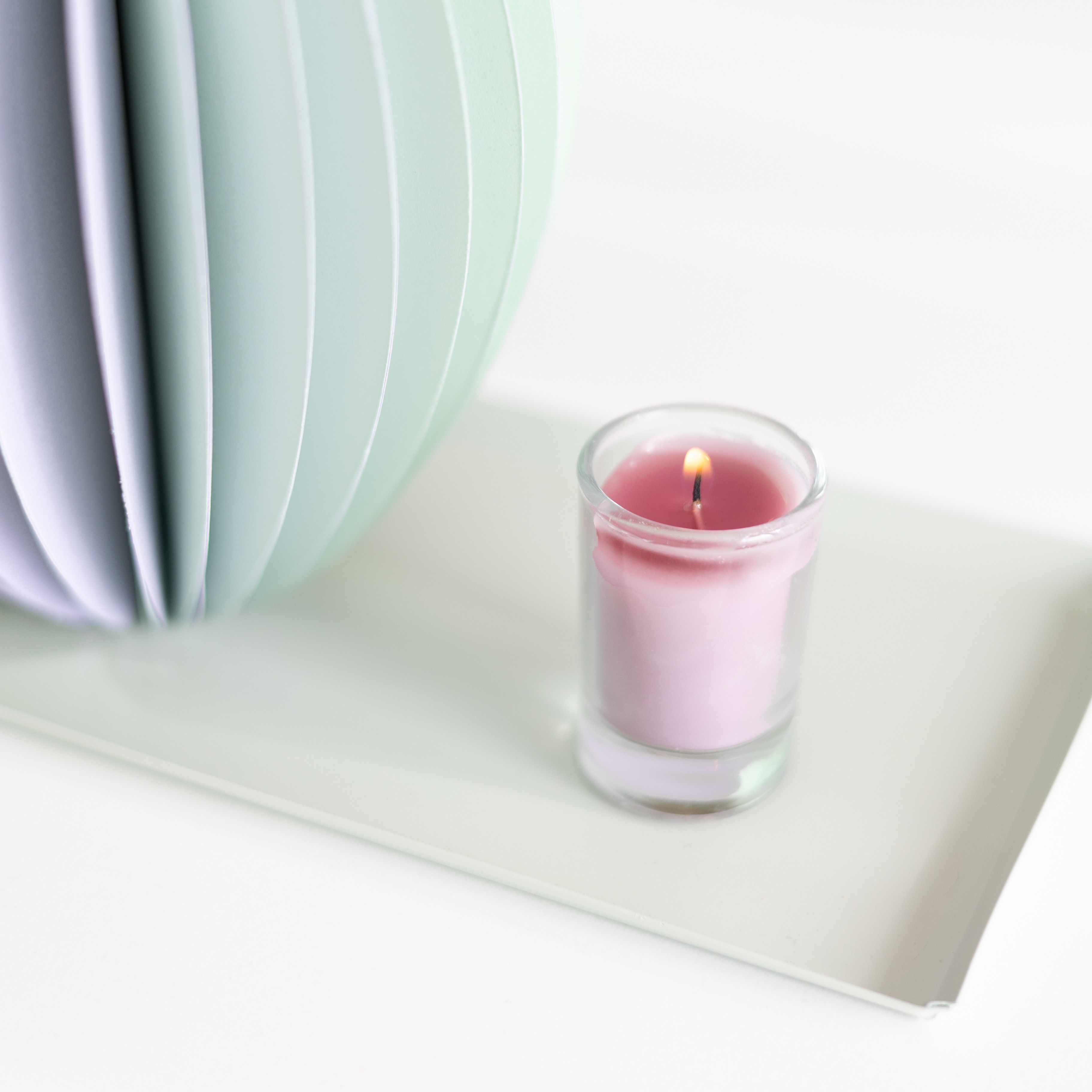 pastel groen en paarse vouwvaas met paarse en naturel droogbloemen en plateau met roze mini kaars