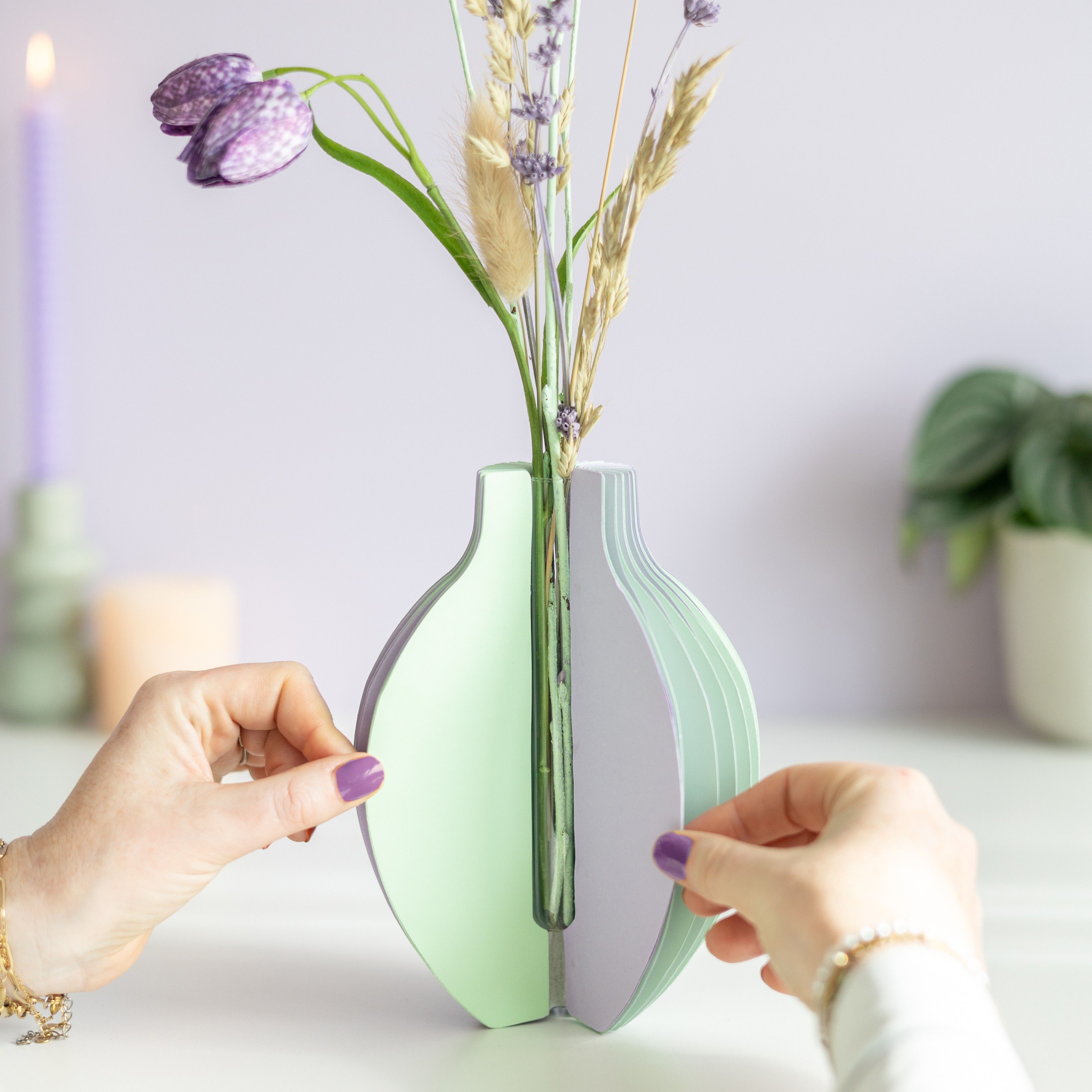 pastel groen en paarse vouwvaas met paarse en naturel droogbloemen en een houten plankje ernaast waar een kaart in gezet kan worden