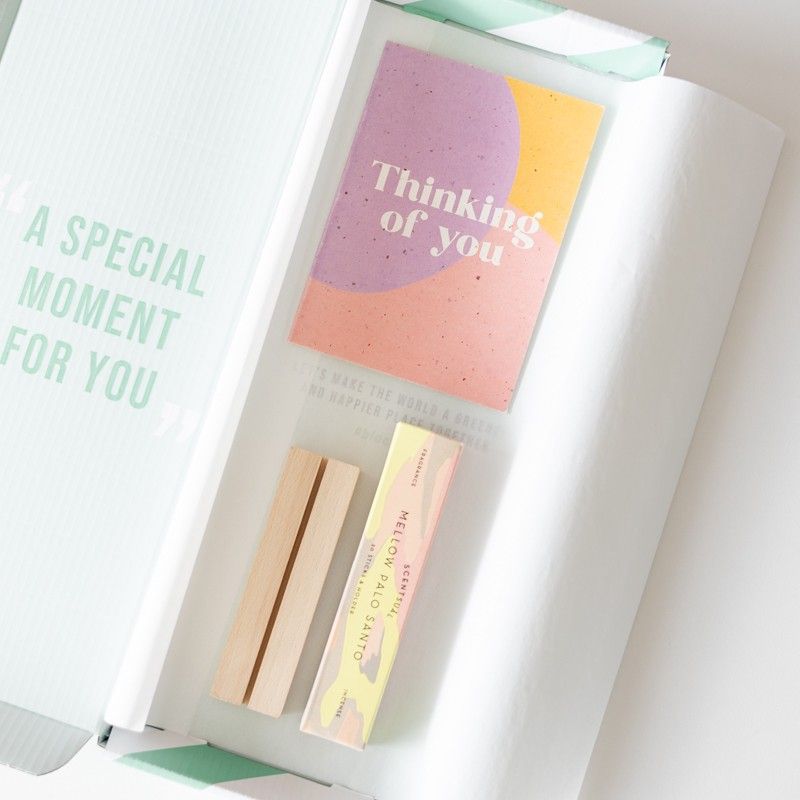 Brievenbuspakketje met Mellow Palo Santo wierrook en een houten blokje waar een wenskaart in past