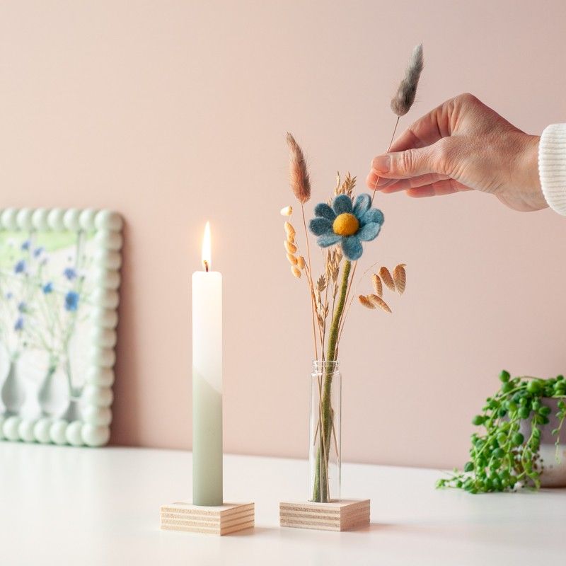 Brievenbuspakketje met wit groene kaars in een houten blokje met daarnaast een vaasje droogbloemen en vilten bloemen in een houten blokje