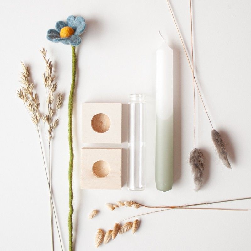 Brievenbuspakketje met wit groene kaars in een houten blokje met daarnaast een vaasje droogbloemen en vilten bloemen in een houten blokje