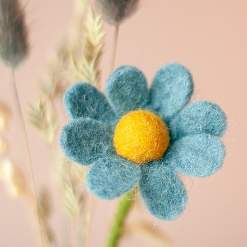 Brievenbuspakketje met wit groene kaars in een houten blokje met daarnaast een vaasje droogbloemen en vilten bloemen in een houten blokje