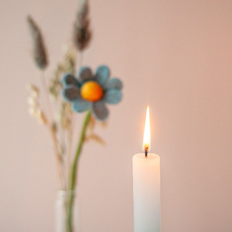 Brievenbuspakketje met wit groene kaars in een houten blokje met daarnaast een vaasje droogbloemen en vilten bloemen in een houten blokje