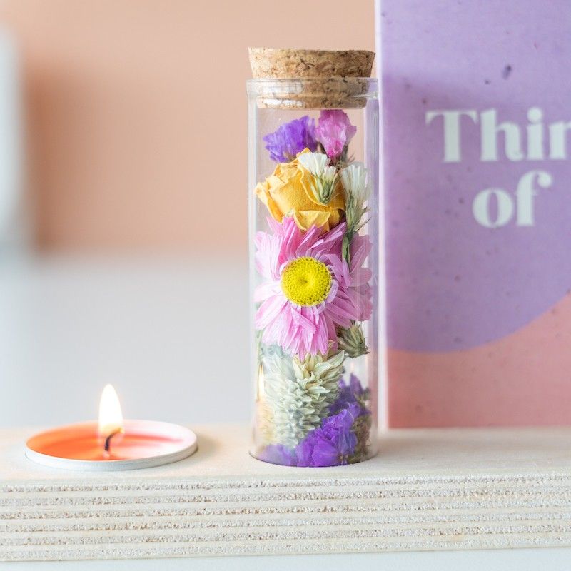 Houten plankje met kaarsje en buisje met droogbloemen. Er is ruimte voor een kaart in het plankje