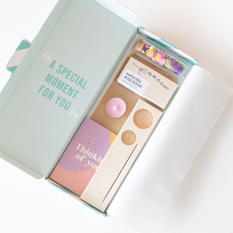 Houten plankje met kaarsje en buisje met droogbloemen. Er is ruimte voor een kaart in het plankje