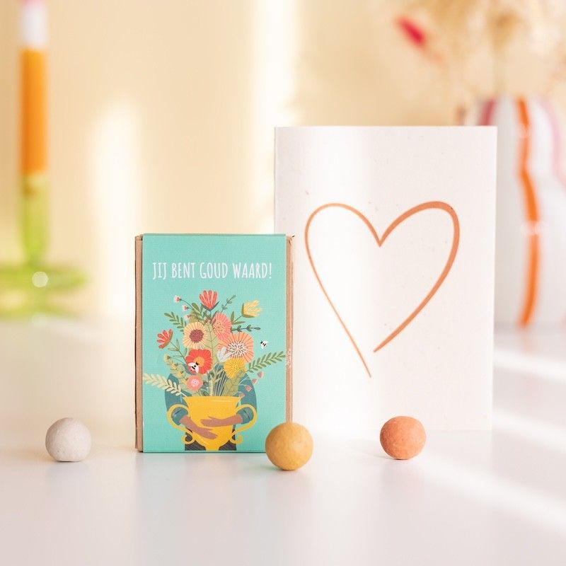 Zaaibommetjes goud waard met een witte wenskaart met oranje hart erop getekend