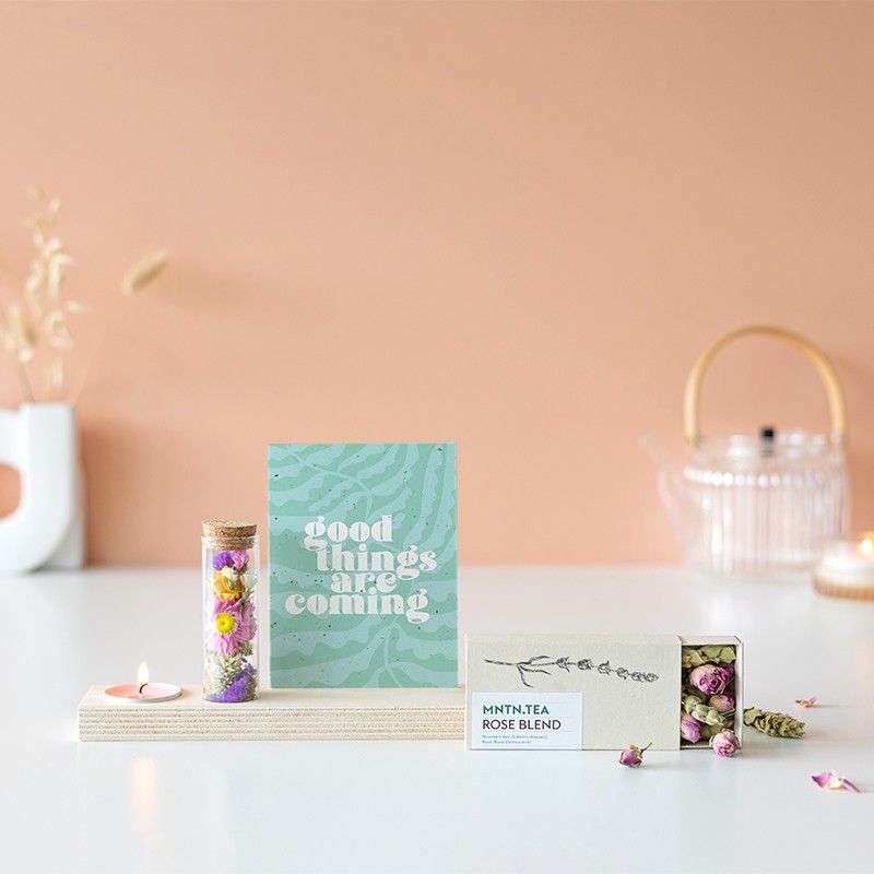 Houten plankje met kaarsje en buisje met droogbloemen. Er is ruimte voor een kaart in het plankje