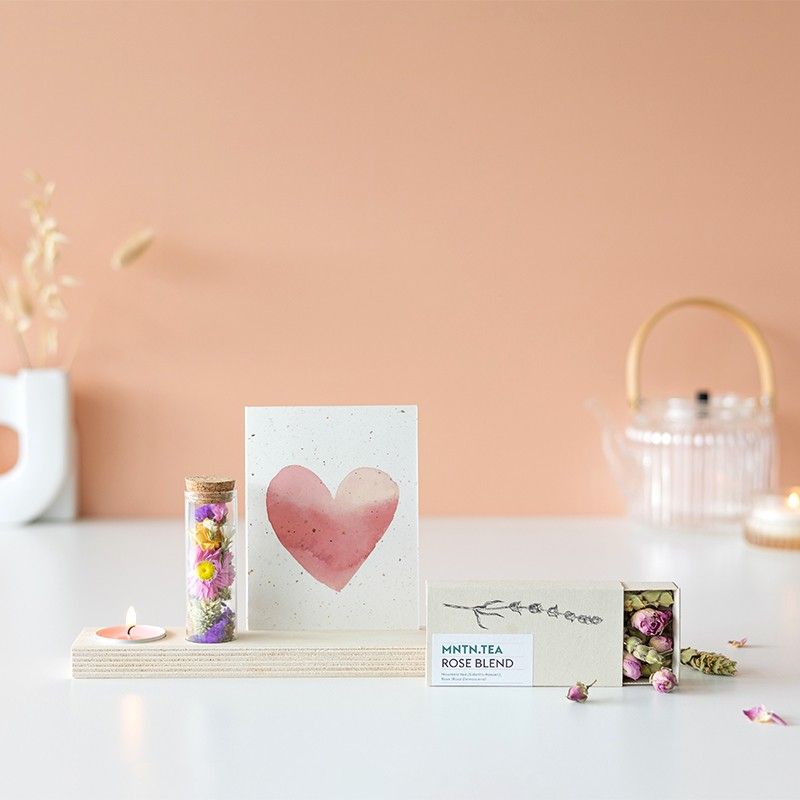 Houten plankje met kaarsje en buisje met droogbloemen. Er is ruimte voor een kaart in het plankje