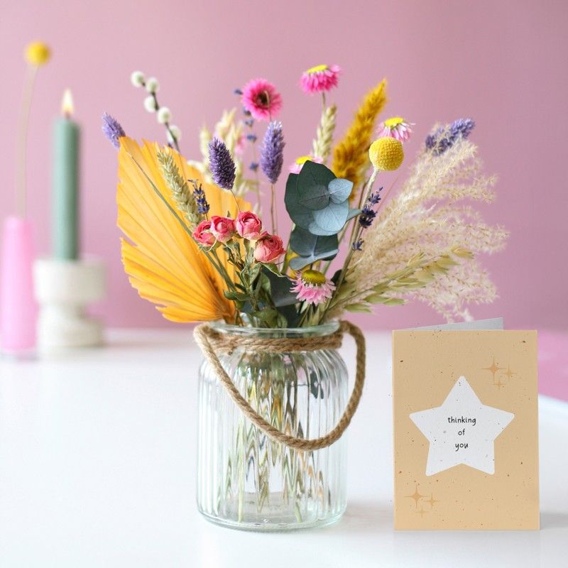 Brievenbuspakketje met droogbloemen in verschillende pastel tinten