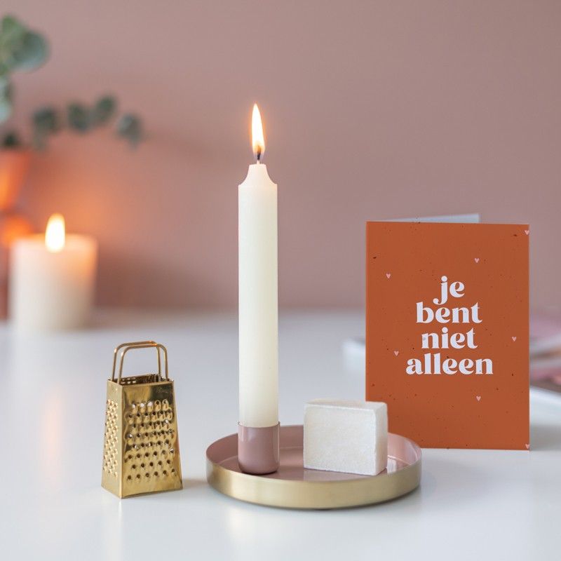 Roze goud schaaltje met een kaars en een amberblokje met daarnaast een gouden rasp