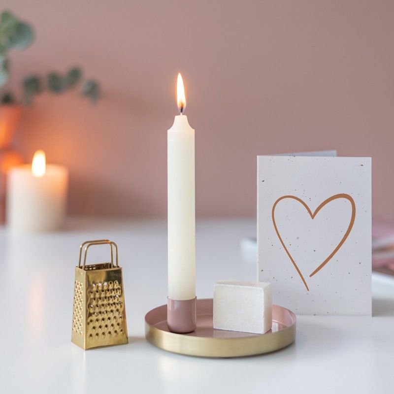 Roze goud schaaltje met een kaars en een amberblokje met daarnaast een gouden rasp
