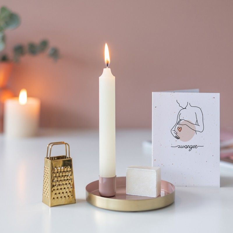 Roze goud schaaltje met een kaars en een amberblokje met daarnaast een gouden rasp