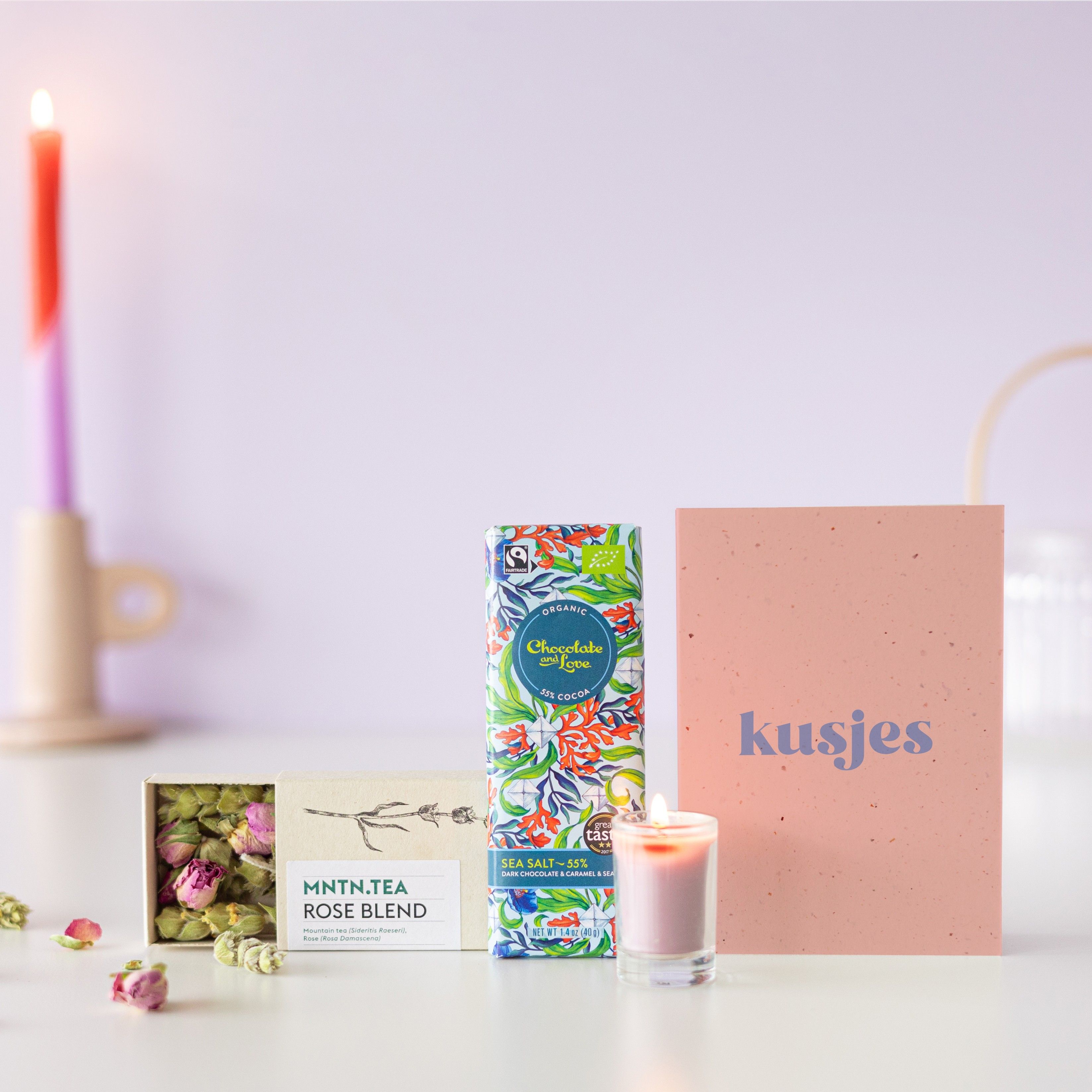 Brievenbuspakketje met een doosje rozen thee, chocolade puur zeezout en een mini roze kaars