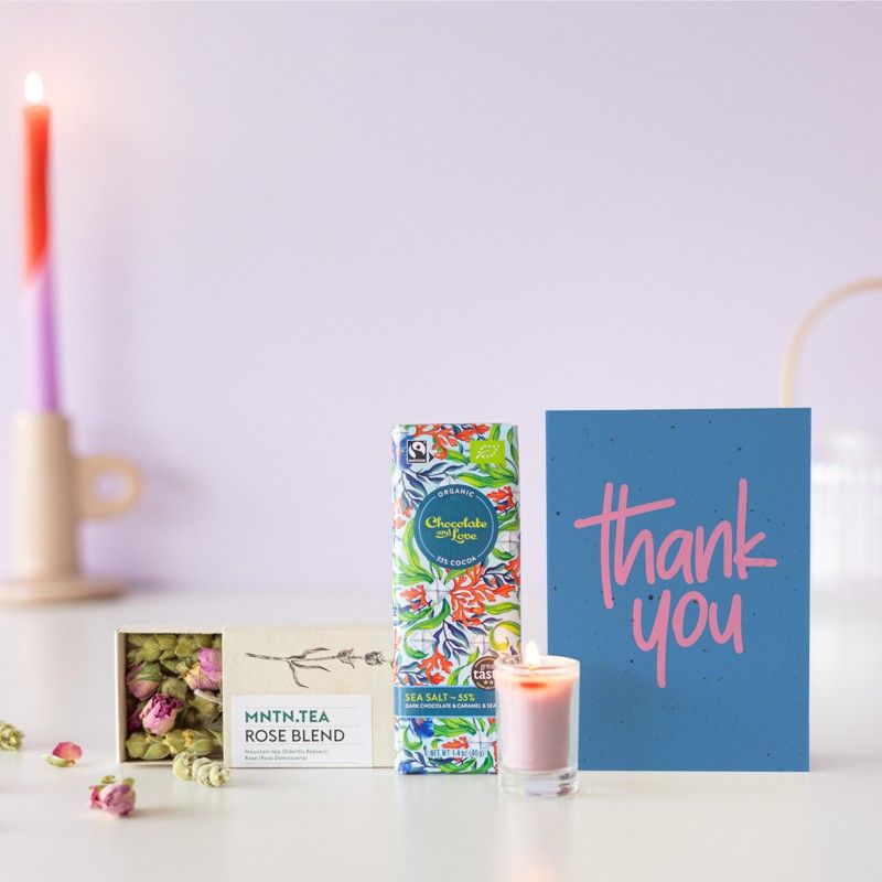 Brievenbuspakketje met een doosje rozen thee, chocolade puur zeezout en een mini roze kaars