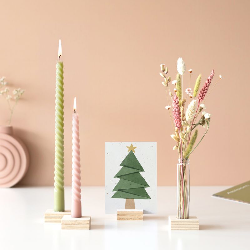 Twee gedraaide kaarsen (groen en roze), een vaasje droogbloemen en wenskaart in houten blokjes als standaard