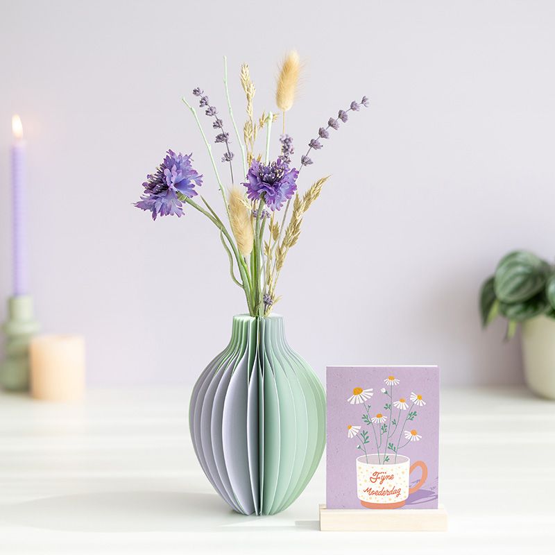 pastel groen en paarse vouwvaas met paarse en naturel droogbloemen en een houten plankje ernaast waar een kaart in gezet kan worden