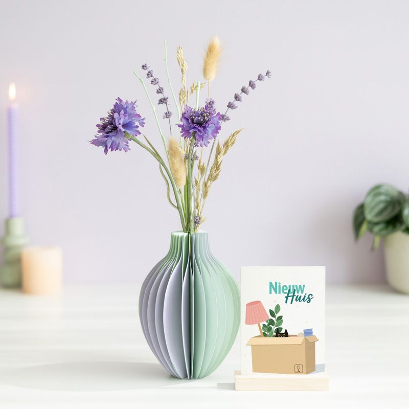 pastel groen en paarse vouwvaas met paarse en naturel droogbloemen en een houten plankje ernaast waar een kaart in gezet kan worden