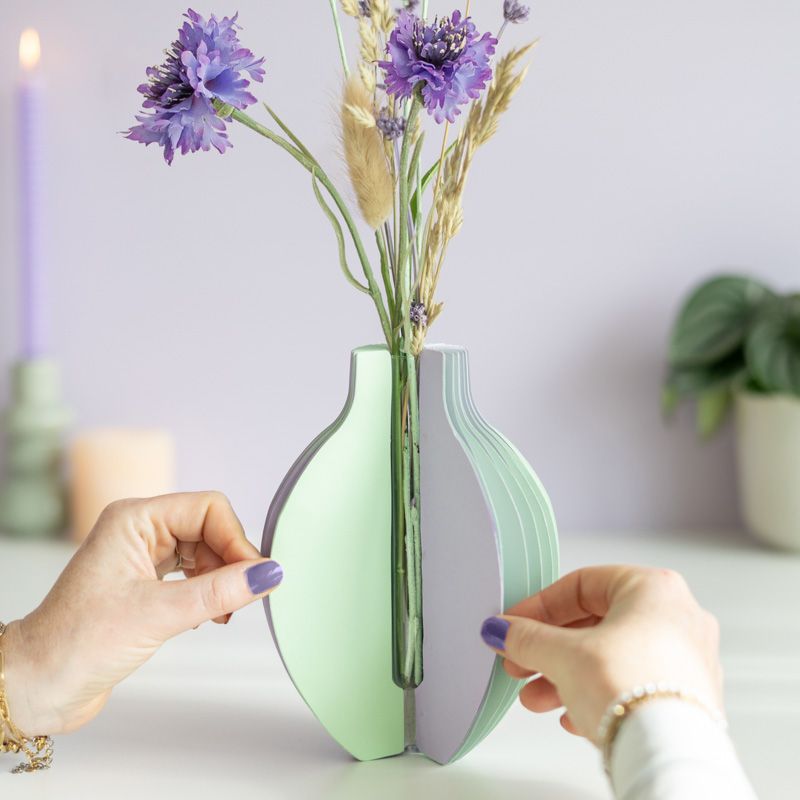 pastel groen en paarse vouwvaas met paarse en naturel droogbloemen en een houten plankje ernaast waar een kaart in gezet kan worden