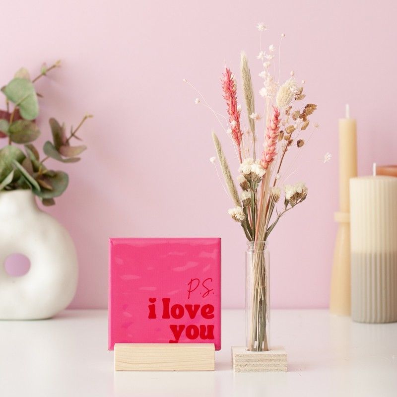 Roze tegeltje met tekst P.S. I love you met een houten standaard, een glazen vaasje, roze en naturel droogbloemen ernaast alles liggend in een brievenbusdoosje.