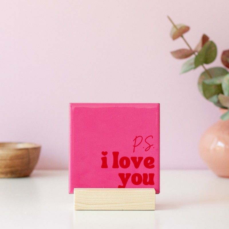Roze tegeltje met P.S. I love you in rode letters in een houten standaard