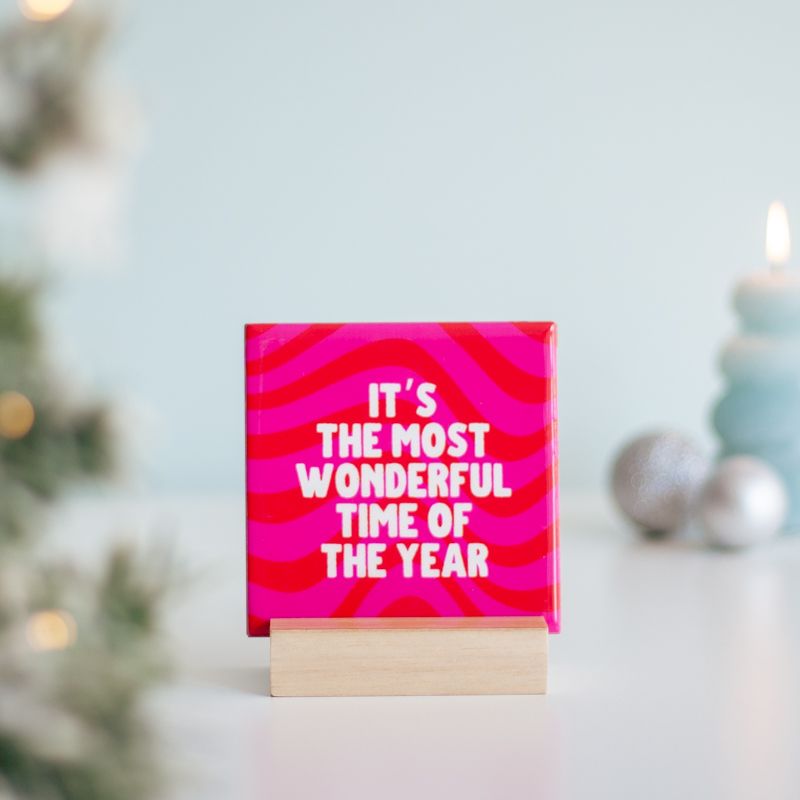 Roze tegeltje met tekst It's the most wonderful time of the year op een houten blokje