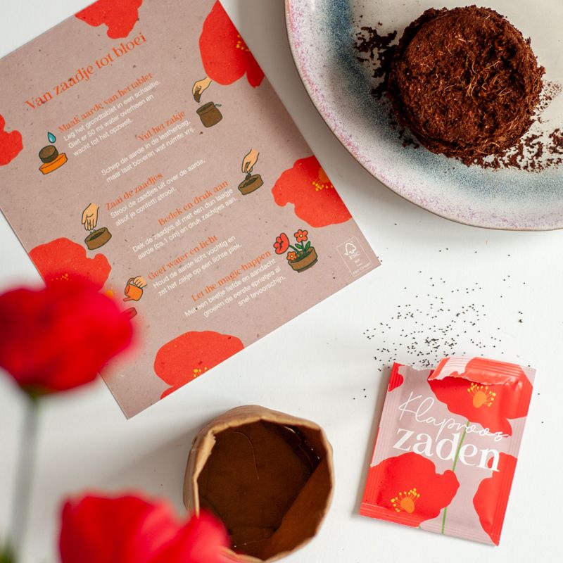 Rood paars doosje met klaproos zaden met daarbij de tekst succes zaaien