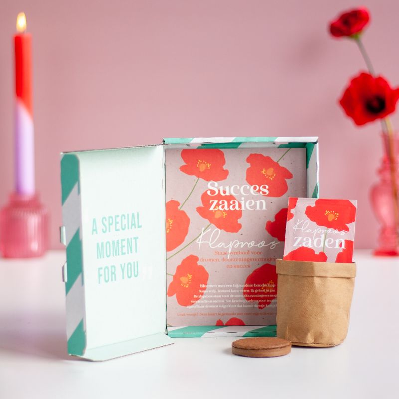Rood paars doosje met klaproos zaden met daarbij de tekst succes zaaien