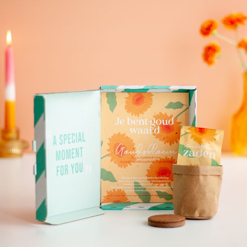 Oranje doosje met goudsbloem zaden met daarbij de tekst je bent goud waard