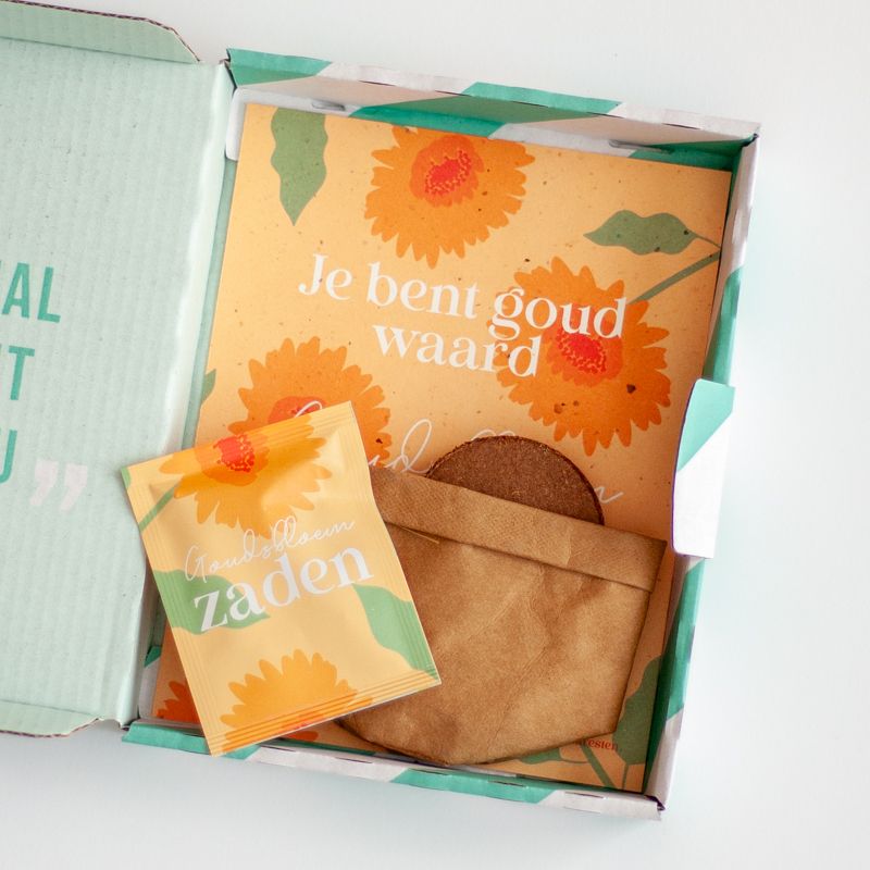 Oranje doosje met goudsbloem zaden met daarbij de tekst je bent goud waard