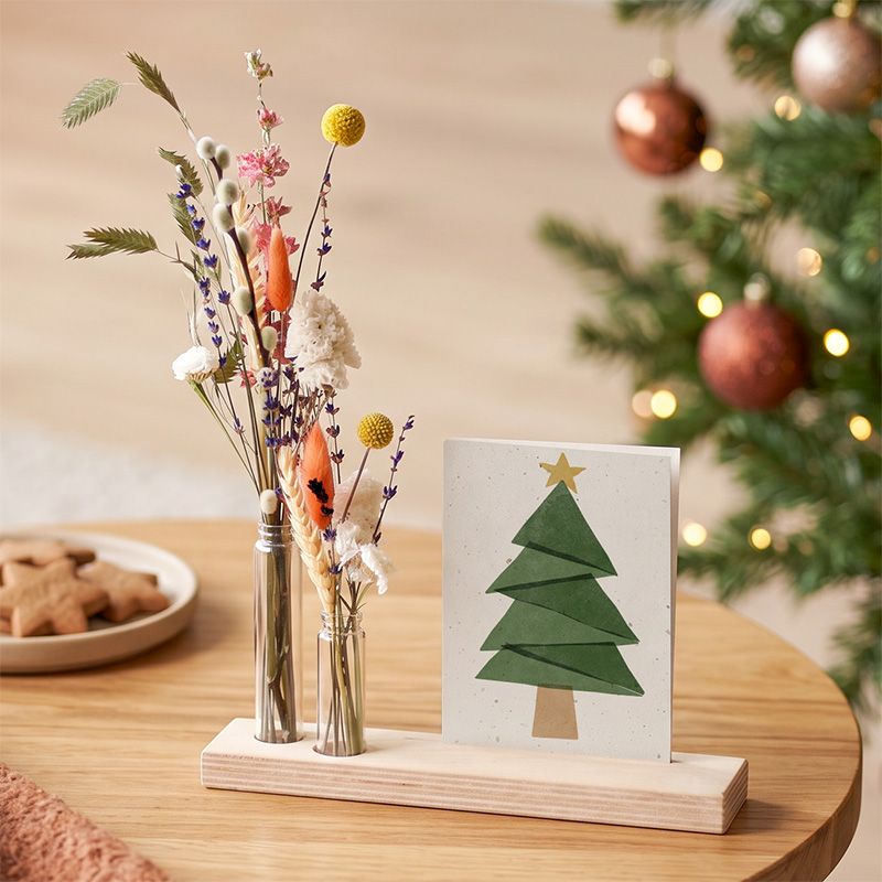 Houten plankje met droogbloemen en kerstkaart