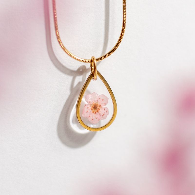 Goudkleurige halsketting met roze bloesem hanger