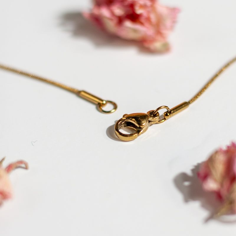 Goudkleurige halsketting met roze bloesem hanger