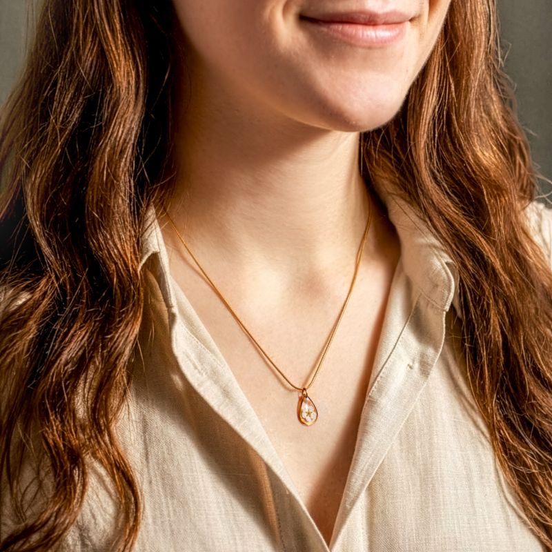 Goudkleurige halsketting met witte bloesem hanger