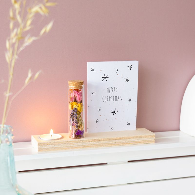 Houten plankje met kaarsje en buisje met droogbloemen. Er is ruimte voor een kaart in het plankje