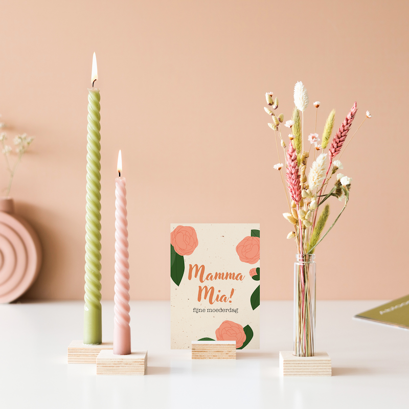 Groene en roze gedraaide kaars met een vaasje met roze en naturel droogbloemen. In het midden staat een wenskaart met mamma mia erop