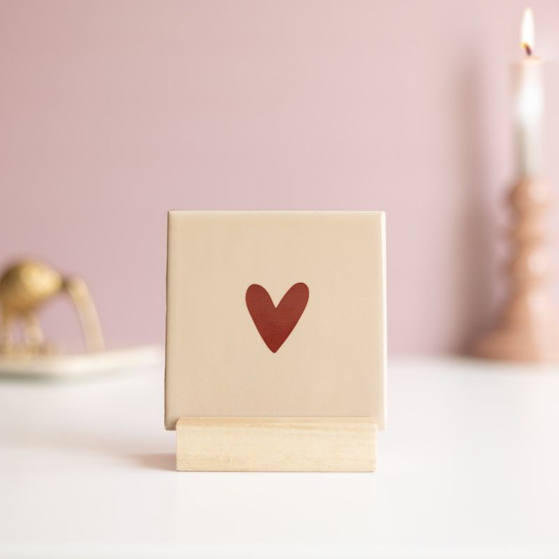 Beige tegel met bruin hartje erop in een houten houdertje