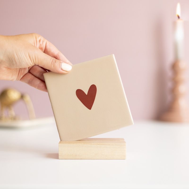 Beige tegel met bruin hartje erop in een houten houdertje