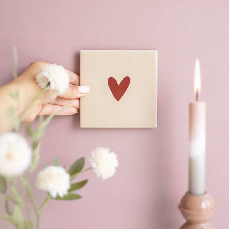 Beige tegel met bruin hartje erop in een houten houdertje